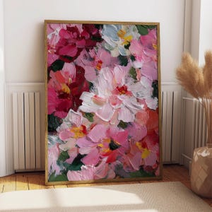 Könnte beinhalten: Gerahmtes Blumenbild mit goldfarbenem Rahmen. Das Kunstwerk zeigt eine Nahaufnahme von rosa, roten, weißen und gelben Blumen mit sichtbaren Pinselstrichen. Das Gemälde wird an einer Wand über einem beigen Teppich ausgestellt.