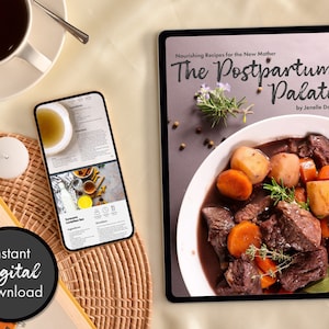 May include: A digital tablet displaying the cover of a cookbook titled "The Postpartum Palate: Nourishing Recipes for the New Mother" by Jenelle Davis. The cover features a close-up of a bowl of beef stew with carrots and potatoes.