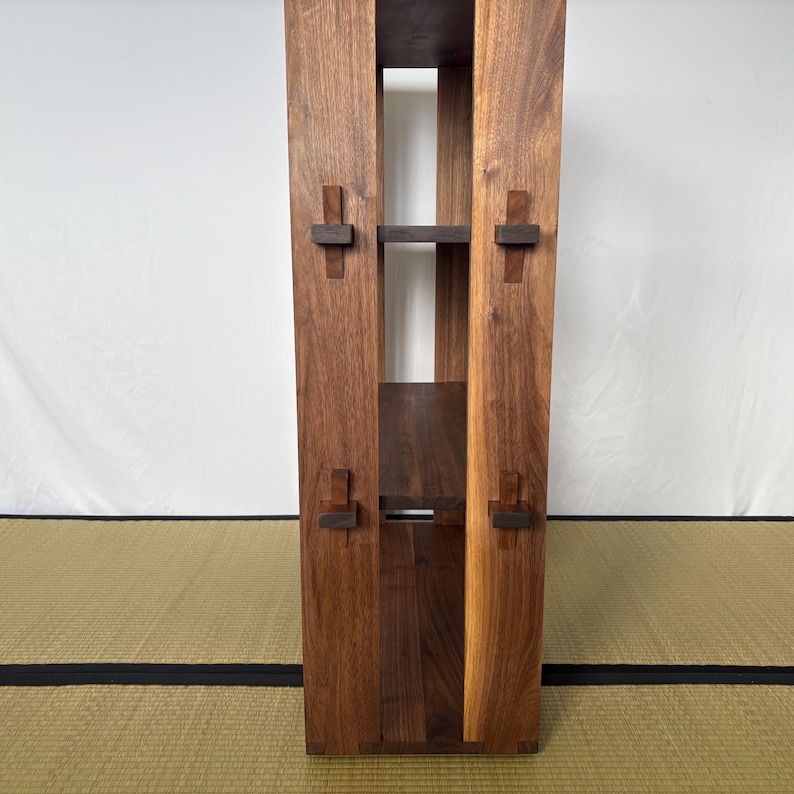 Peut inclure: Une &eacute;tag&egrave;re en bois avec trois tablettes et une finition brun fonc&eacute;. Les tablettes sont soutenues par des supports en bois fix&eacute;s sur les c&ocirc;t&eacute;s de l'unit&eacute;.