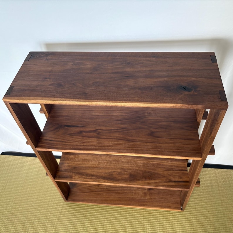 Peut inclure: Une &eacute;tag&egrave;re en bois brun fonc&eacute; avec trois &eacute;tag&egrave;res. Les &eacute;tag&egrave;res sont en bois massif et ont une finition naturelle. L'&eacute;tag&egrave;re est autoportante et a un design simple et moderne.