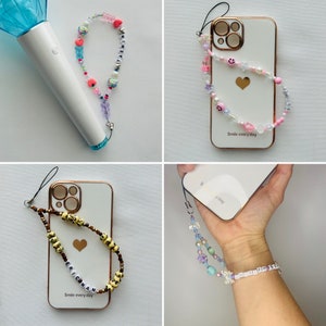 May include: A collection of beaded phone charms and a light stick. The charms feature various colorful beads, including hearts, smiley faces, and letter beads spelling out names. One phone case has a gold border and the text "Smile everyday".