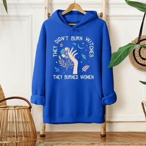 a blue hoodie that says they don't burn nices they buried women