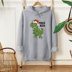 a gray hoodie with a green dinosaur wearing a santa hat