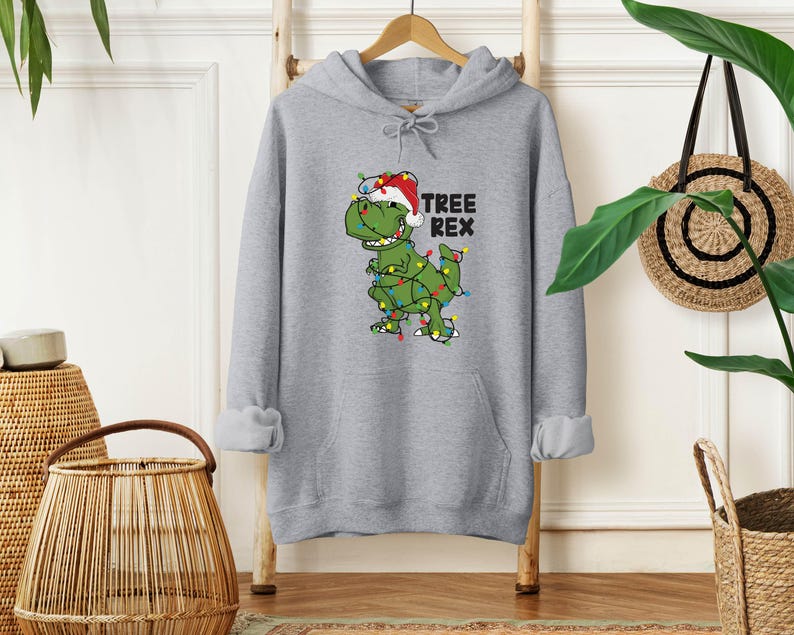 a gray hoodie with a green dinosaur wearing a santa hat
