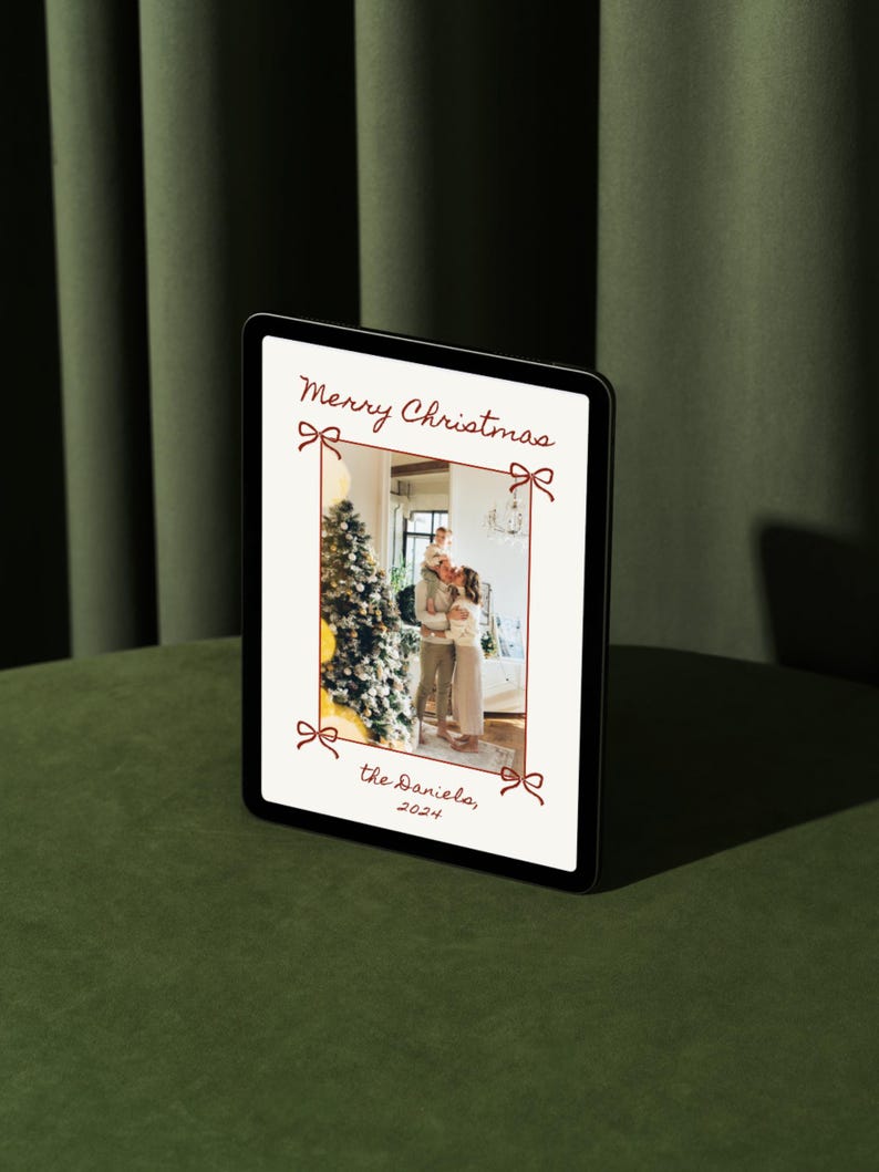 Puede incluir: Una tarjeta de Navidad digital con una foto de una familia de pie frente a un &aacute;rbol de Navidad decorado. La tarjeta tiene un borde rojo con lazos y el texto "Feliz Navidad, los Daniels, 2021".