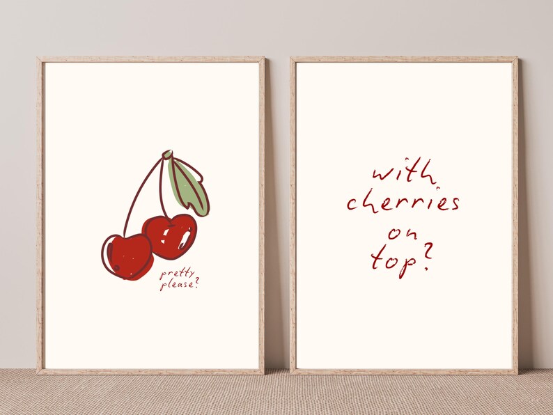 Puede incluir: Dos impresiones art&iacute;sticas enmarcadas con fondo crema. Una impresi&oacute;n presenta una ilustraci&oacute;n de cerezas con el texto "pretty please?". La otra dice "with cherries on top?" en escritura roja.