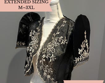 May include: A black bolero jacket featuring sheer fabric, structured butterfly sleeves, and intricate cream-colored floral embroidery along the edges. The garment displays the text EXTENDED SIZING M-3XL on a pink banner at the top left corner.