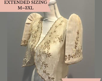 May include: A cream-colored bolero jacket featuring stiff butterfly sleeves and intricate floral embroidery along the edges. The garment has a scalloped hemline and is displayed on a mannequin. Text on the image reads EXTENDED SIZING M-3XL.