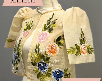 May include: A cream-colored bolero jacket featuring short, puffed sleeves and a high collar. The garment is decorated with hand-painted floral motifs in shades of pink, orange, and blue, accompanied by green leaves. The text PETITE FIT is visible.