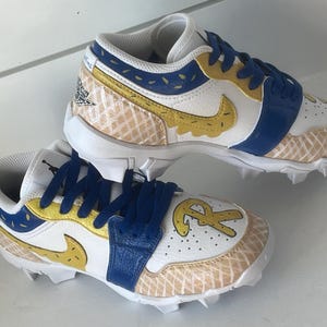 Puede incluir: Par de tacos blancos, azules y amarillos con un dise&ntilde;o &uacute;nico. Los zapatos presentan una correa azul, detalles amarillos y un patr&oacute;n de gofre. El logo de Nike es amarillo. Los zapatos tienen un logo en el lateral y las letras "R" y "R" en la puntera.