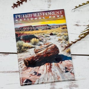 May include: A rectangular magnet featuring a landscape of Petrified Forest National Park in Arizona. The magnet displays a colorful desert scene with a petrified log in the foreground and the park's name at the top.