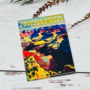 Può includere: Magnete rettangolare con un'illustrazione colorata del Grand Canyon National Park in Arizona. Il magnete presenta il testo "GRAND CANYON NATIONAL PARK" e "EST. 1919". L'opera d'arte raffigura le formazioni rocciose del canyon in tonalità rosse, gialle e blu.