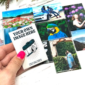 May include: A collection of rectangular photo tiles, each displaying a different image. One tile features the text "YOUR OWN IMAGE HERE" with a camera graphic and the dimensions "2x3 INCHES". Other tiles show various photographs.