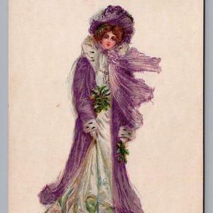 Cartolina d'auguri di Natale in seta antica del 1909, raffigurante una signora vittoriana edoardiana alla moda con un cappotto viola con rifiniture in pelliccia bianca.