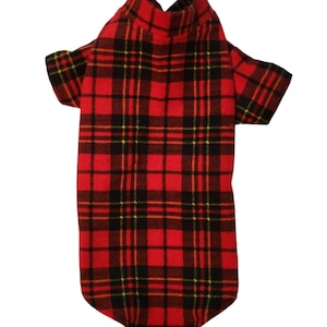 May include: Red and black plaid dog shirt with a turtleneck collar. The shirt has short sleeves and a classic tartan pattern. The fabric appears to be a woven material, suitable for cooler weather. The overall design is a traditional style.