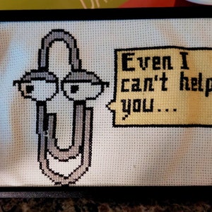 May include: Cross-stitch embroidery of a paperclip with eyes and a speech bubble that says "Even I can't help you..."