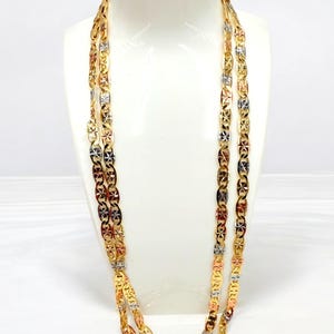 May include: Three gold-toned necklaces displayed on a white mannequin. Each necklace features a repeating pattern of star-shaped links. The links are gold, silver, and rose gold, creating a tricolor effect. The necklaces are draped to show their length and design.