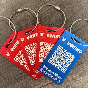 May include: Four red luggage tags with a QR code and the text "V venmo" and one blue luggage tag with a QR code, the text "V venmo", and the text "Brandon Blake @brandoblak_7".