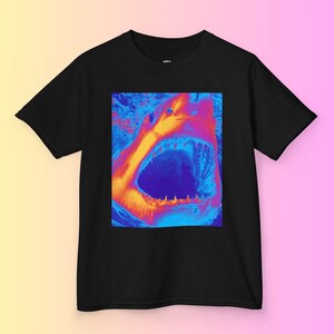 Op de afbeelding: Een zwart T-shirt met een afbeelding van een open haaienbek in een levendig, psychedelisch kleurenschema van oranje, blauw en paars.