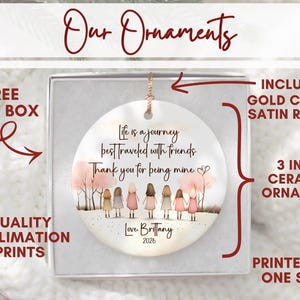 May include: A 3-inch round white ceramic ornament featuring a printed illustration of seven friends holding hands under pink trees. The text reads: Life is a journey best traveled with friends. Thank you for being mine. Love, Brittany 2026.