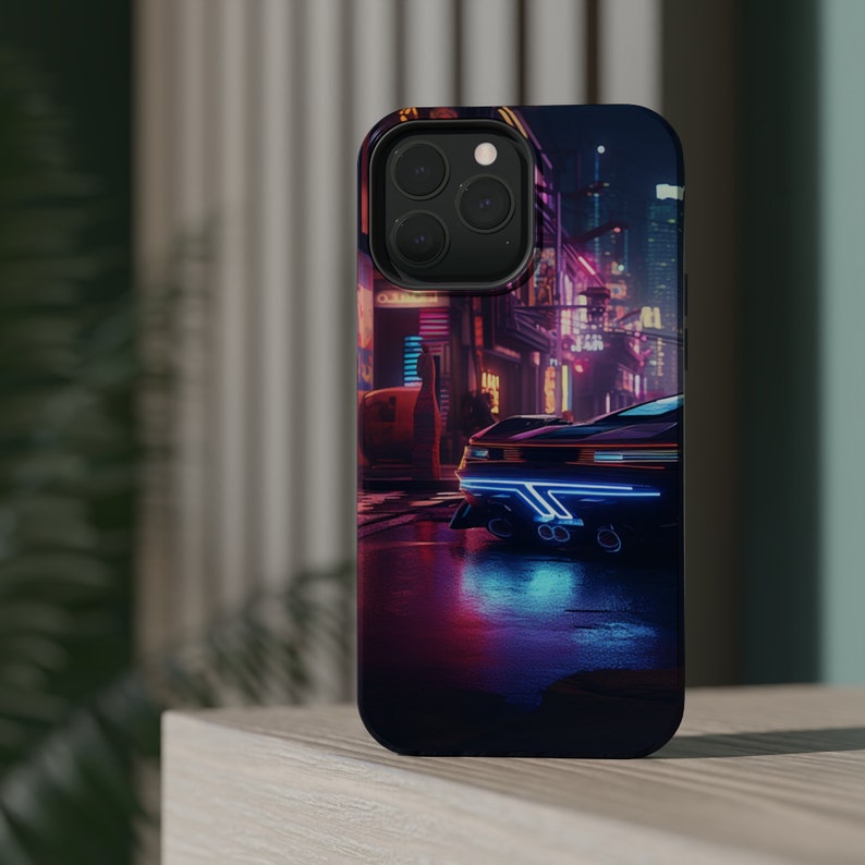 May include: A black phone case featuring a neon cityscape with a futuristic car in the foreground. The car has blue lights and is driving through a wet street.