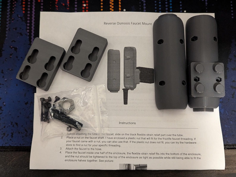 May include: Instructions for installing a reverse osmosis faucet mount. The kit includes two black plastic pieces, a nut, screws, and a strain relief part. The instructions include steps for attaching the faucet to the hose and securing the mount.