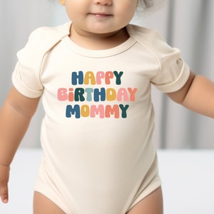 a baby in a bodysuit with the words happy birthday mommy on it