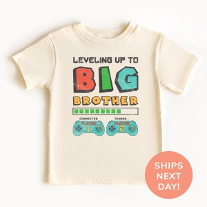a t - shirt with the words, leveling up to big brother on it