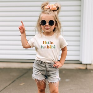 a little girl wearing a little habi t - shirt