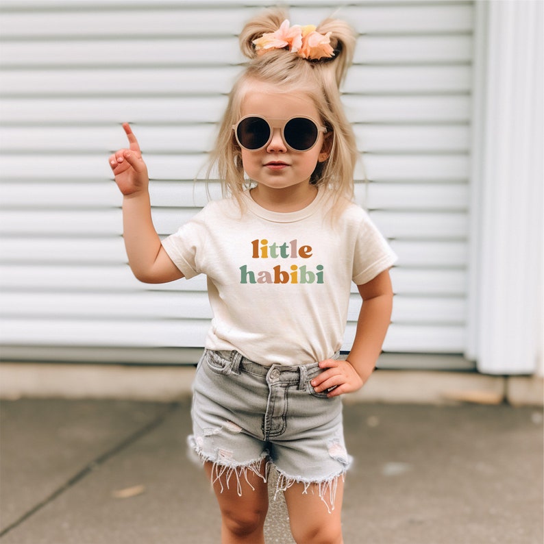 a little girl wearing a little habi t - shirt