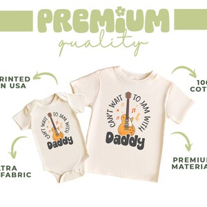 a baby's bodysuit with a guitar on it