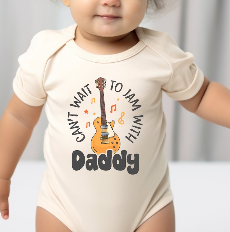 a baby wearing a bodysuit with a guitar on it