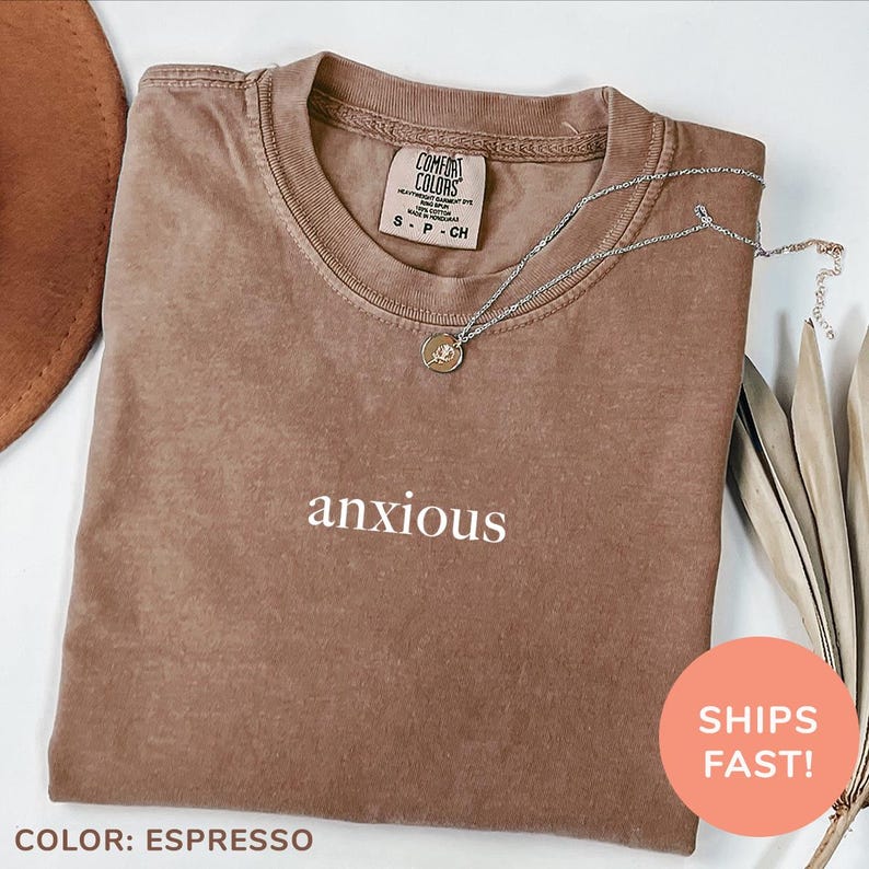 a brown t - shirt with the word anxious written on it