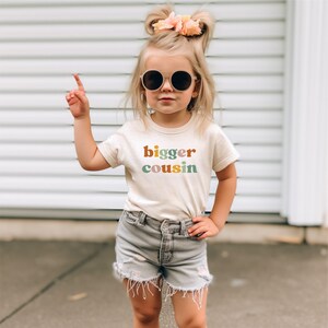 a little girl wearing sunglasses and a t - shirt