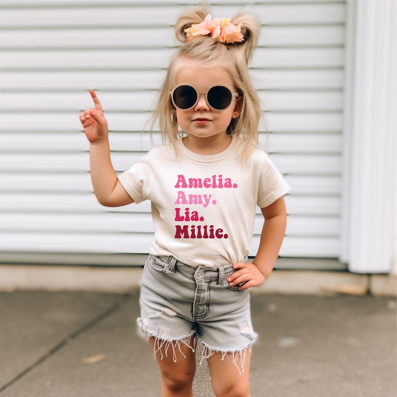 a little girl wearing sunglasses and a t - shirt