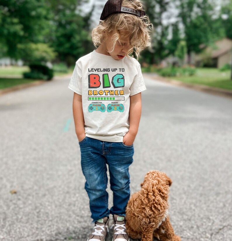 a little boy standing next to a brown dog