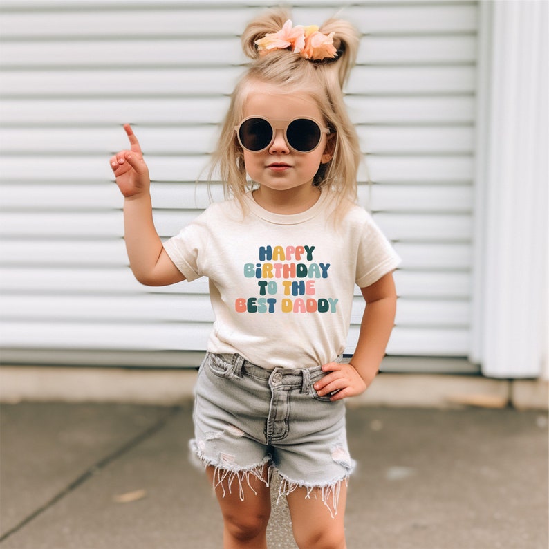 a little girl wearing sunglasses and a happy birthday t - shirt