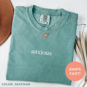 a t - shirt with the words anxious on it