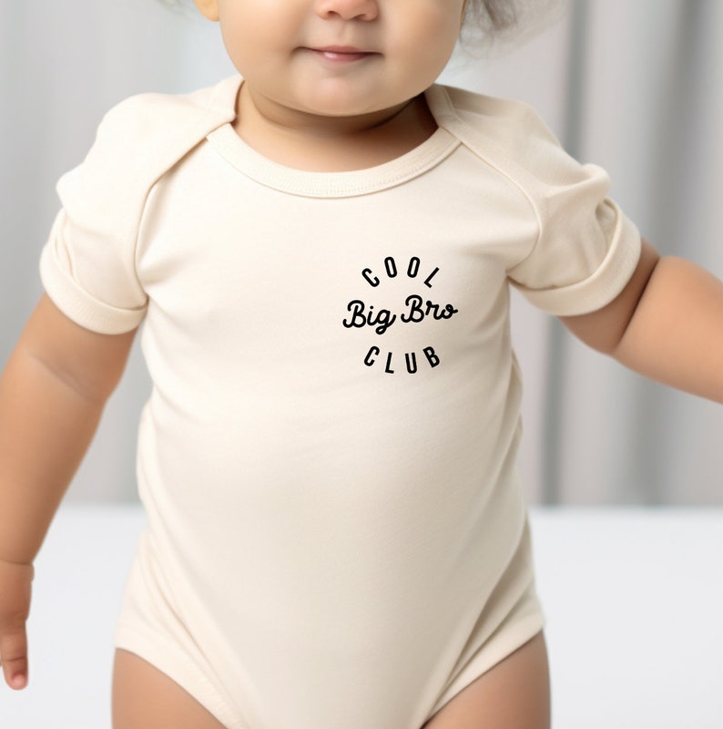 a baby wearing a bodysuit with the words big bro club on it