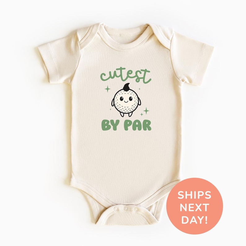 A white baby onesie with a cute cartoon character and the text "cutest by par" printed on it.