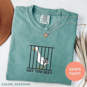 a t - shirt with a picture of a goose in a cage