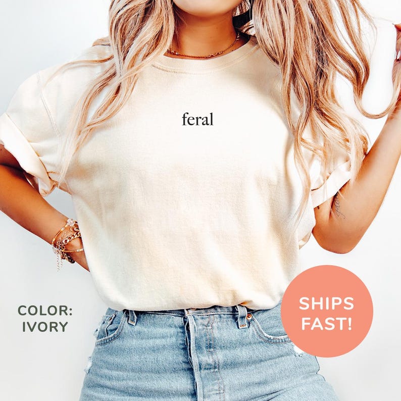 a woman wearing a white shirt with the word feral printed on it