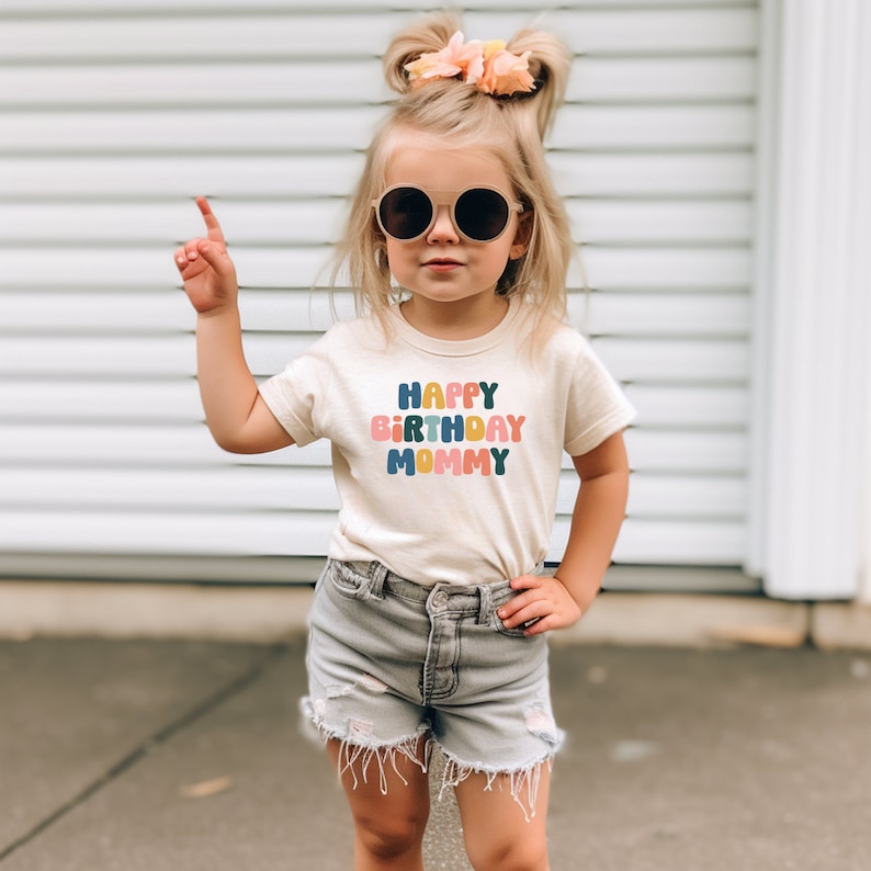 a little girl wearing sunglasses and a happy birthday shirt