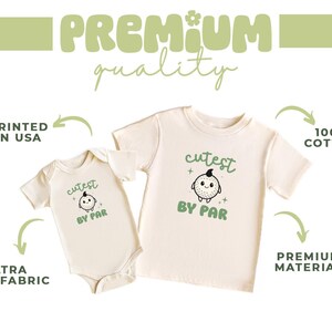 two white t-shirts with a cute cartoon character printed on them. The t-shirts are described as "PREMIUM quality" and "PRINTED IN USA", indicating that they are made of 100% cotton and are printed in the USA. The t-shirts are also described as "ULTRA soft fabric" and "PREMIUM material", suggesting that they are made of high-quality materials and have a premium feel.