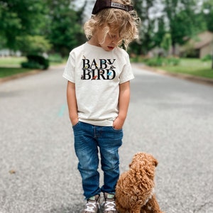 a little boy standing next to a brown dog