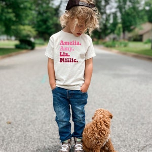 a little boy standing next to a brown dog