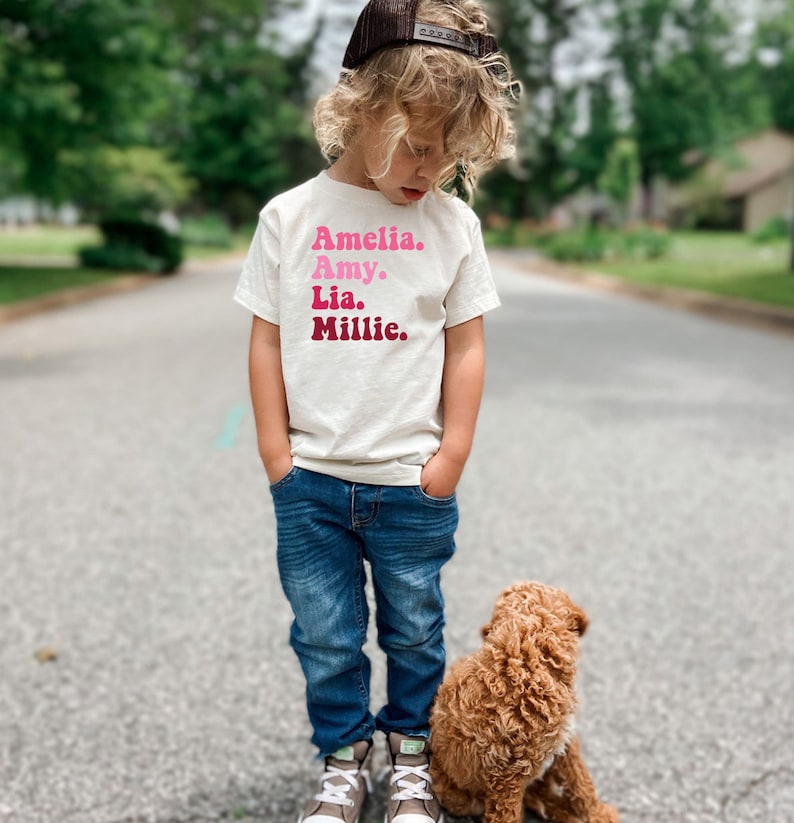 a little boy standing next to a brown dog