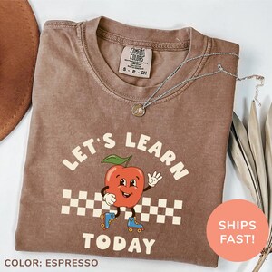 a brown shirt with a picture of a tomato on it