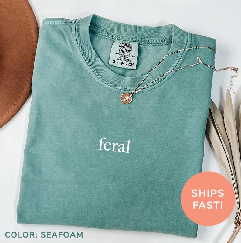 a green shirt with the word feral on it