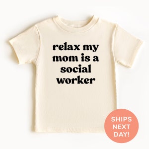 May include: A cream-colored short-sleeved t-shirt with the text "relax my mom is a social worker" printed in black.